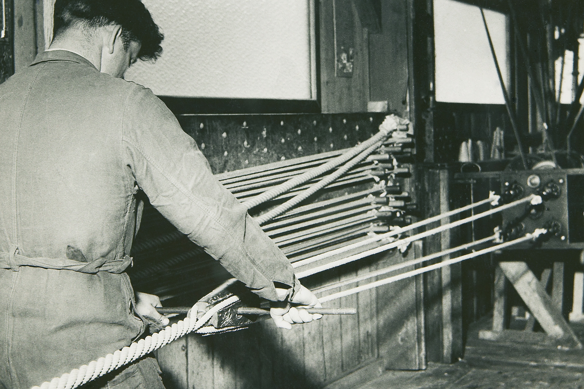[Translate to Japan (JP), Japanese (Default):] An old photography of a worker producing a fibre rope in the 1950s